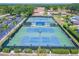 A community tennis court is seen from above, with mature trees and parking surrounding the area at 2862 Lomond Dr, Palm Harbor, FL 34684