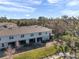 Aerial shot of a townhome's backyard with a screened patio, a pond, and lush landscaping, creating a private oasis at 2907 Jacob Crossing Ln, Holiday, FL 34691