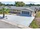 A charming single-story home, with an extended driveway leading to a garage, surrounded by a well-maintained yard at 3736 Sail Dr, New Port Richey, FL 34652