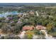 Charming single-story home boasts a screened pool, lush landscaping, and picturesque lake views at 4603 Lake In The Woods Dr, Spring Hill, FL 34607