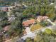 Aerial view of a charming single-story home with a screened pool surrounded by mature trees at 4603 Lake In The Woods Dr, Spring Hill, FL 34607