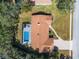 Aerial view of a charming single-story home with a screened pool, lush landscaping, and a brick driveway at 4603 Lake In The Woods Dr, Spring Hill, FL 34607