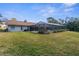 The home's backyard showcases an enclosed pool and covered area with serene outdoor living at 4603 Lake In The Woods Dr, Spring Hill, FL 34607
