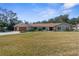 Traditional single-story home boasts a well-manicured lawn and mature trees for added privacy at 4603 Lake In The Woods Dr, Spring Hill, FL 34607