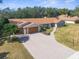 A charming single-story home boasts a brick driveway, mature trees, and a well-manicured lawn at 4603 Lake In The Woods Dr, Spring Hill, FL 34607