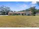 Charming single-story home features a well-manicured lawn and mature trees providing ample shade at 4603 Lake In The Woods Dr, Spring Hill, FL 34607