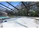 Inviting hot tub under a screened enclosure, with a swimming pool and natural surroundings for ultimate relaxation at 4603 Lake In The Woods Dr, Spring Hill, FL 34607