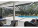 Comfortable outdoor seating area looking out onto a screened pool at 4603 Lake In The Woods Dr, Spring Hill, FL 34607