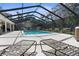Gorgeous screened pool area with lounge chairs perfect for relaxing poolside at 4603 Lake In The Woods Dr, Spring Hill, FL 34607