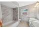 This bathroom features tile floors, a shower over tub, a vanity, and a window at 4929 Avery Rd, New Port Richey, FL 34652