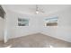 This bedroom features tile flooring, a ceiling fan, and two windows at 4929 Avery Rd, New Port Richey, FL 34652