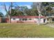 Charming single-story home with red tile roof, wooden fence, and lush front lawn at 4929 Avery Rd, New Port Richey, FL 34652