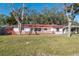 Charming single-story home with red tile roof, wooden fence, and lush front lawn at 4929 Avery Rd, New Port Richey, FL 34652