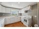 Bright kitchen features white appliances, cabinets, and a window for natural light at 4929 Avery Rd, New Port Richey, FL 34652