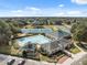 An aerial view of the community clubhouse, swimming pool, tennis courts, playground and parking at 5351 Championship Cup Ln, Spring Hill, FL 34609