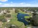 Aerial view of the lush golf course community with a serene pond and meticulously manicured greens at 5351 Championship Cup Ln, Spring Hill, FL 34609
