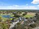 Aerial view showcasing the golf course, serene pond, and community homes amidst lush greenery at 5351 Championship Cup Ln, Spring Hill, FL 34609