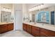 Bathroom with double sinks, dark wood cabinets, and a large mirror for a seamless look at 5351 Championship Cup Ln, Spring Hill, FL 34609