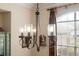 Close-up of a chandelier with glass shades and bronze-finished metalwork in dining room at 5351 Championship Cup Ln, Spring Hill, FL 34609