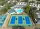 Aerial view of community amenities, including tennis courts, a pool, and a playground surrounded by homes at 5351 Championship Cup Ln, Spring Hill, FL 34609