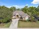 Charming single-story home featuring lush landscaping, mature trees, and a paved driveway at 5351 Championship Cup Ln, Spring Hill, FL 34609