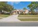 Charming one-story home with a well-manicured lawn, mature landscaping, and a long concrete driveway at 5351 Championship Cup Ln, Spring Hill, FL 34609