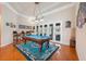 Elegant game room with a billiards table, hardwood floors, and access to the outdoor area at 5351 Championship Cup Ln, Spring Hill, FL 34609
