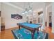 Game room showcasing a billiards table, hardwood floors, and a view into the dining room at 5351 Championship Cup Ln, Spring Hill, FL 34609