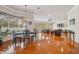 A large living room and breakfast nook featuring wood floors, natural lighting, and comfortable seating at 5351 Championship Cup Ln, Spring Hill, FL 34609