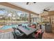 Covered patio with a large dining table and seating area overlooking the pool at 5351 Championship Cup Ln, Spring Hill, FL 34609