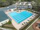 Aerial shot of a large community swimming pool with lounge chairs and shaded seating areas at 5351 Championship Cup Ln, Spring Hill, FL 34609