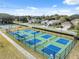 Aerial view of tennis and pickleball courts within a residential community, lined by trees and homes at 5351 Championship Cup Ln, Spring Hill, FL 34609