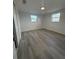 Bedroom with gray wood flooring, light walls and a large window for natural light at 5352 Palm Dr, New Port Richey, FL 34652