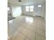 Bright living room featuring tile flooring, a large window, and a white front door at 5352 Palm Dr, New Port Richey, FL 34652