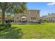 Vast backyard featuring an outdoor kitchen, patio dining, and lush green spaces, perfect for entertaining and enjoying nature at 5412 Hammock View Ln, Apollo Beach, FL 33572