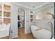 Luxurious bathroom with a standalone tub and a view into the walk-in closet at 5412 Hammock View Ln, Apollo Beach, FL 33572