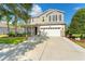 Charming two-story home featuring a well-maintained lawn, a two-car garage, and a welcoming front porch at 5412 Hammock View Ln, Apollo Beach, FL 33572