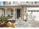 Inviting front porch with seating, decorative columns, and a well-manicured garden leading to the front door at 5412 Hammock View Ln, Apollo Beach, FL 33572