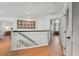 Upstairs hallway featuring wood flooring, white banisters, and a stylish decor piece at 5412 Hammock View Ln, Apollo Beach, FL 33572