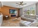 Bright living room boasts a feature wall with fireplace, TV, and expansive windows overlooking the manicured backyard at 5412 Hammock View Ln, Apollo Beach, FL 33572