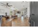 Open-concept living and dining area with tile floors, a decorative brick wall, and a staircase to the upper level at 5412 Hammock View Ln, Apollo Beach, FL 33572