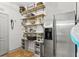 Well-organized pantry with stainless steel refrigerator and ample storage shelving at 5412 Hammock View Ln, Apollo Beach, FL 33572