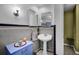 Bathroom featuring a pedestal sink, decorative mirrors, and blue storage unit at 6495 Fairlawn St, Spring Hill, FL 34606