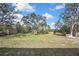 Expansive backyard featuring mature trees and lush green grass, perfect for outdoor activities at 7399 Skylark Dr, Spring Hill, FL 34606