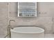 Bright bathroom featuring soaking tub, marble tile backsplash, and chrome fixtures at 7399 Skylark Dr, Spring Hill, FL 34606
