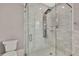 Bright bathroom featuring large glass shower with rainfall shower head and toilet at 7399 Skylark Dr, Spring Hill, FL 34606