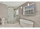 Bright bathroom featuring soaking tub, glass shower with rainfall shower head, and toilet at 7399 Skylark Dr, Spring Hill, FL 34606