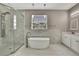 Bright bathroom featuring soaking tub, glass shower, white marble tile, and double pendant lighting at 7399 Skylark Dr, Spring Hill, FL 34606