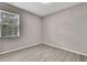 Bedroom with light gray walls, gray laminate flooring and bright natural light at 7399 Skylark Dr, Spring Hill, FL 34606