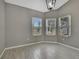 This dining room features wood-look tile flooring, three windows and gray walls at 7399 Skylark Dr, Spring Hill, FL 34606